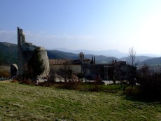 au Nord, un mur d'enceinte barre l'accès au village. 
  A gauche, le  donjon, forte tour cylindrique du XIVe s. domine l'église romane Saint-Pierre, du XIIe s. ; 
  à droite la Porte de la Herse perce le rempart
